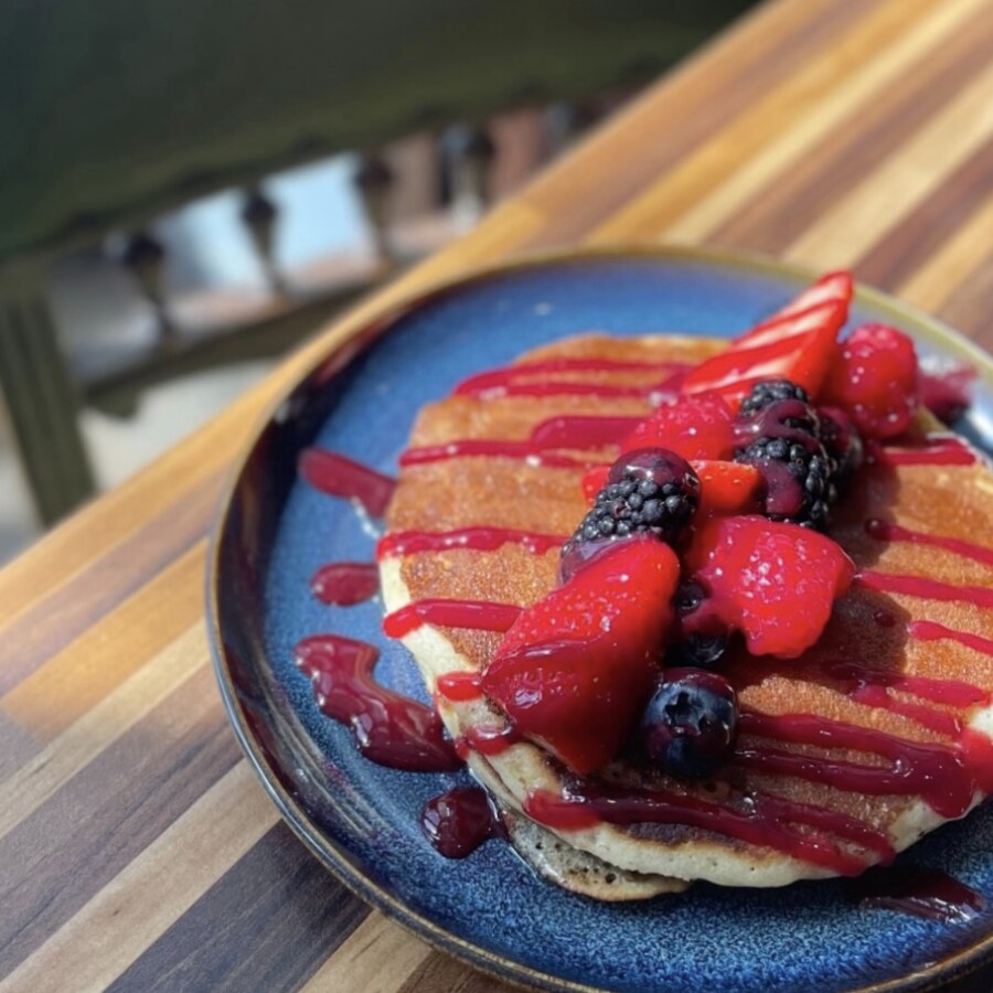 Pile de pancakes fruités nappés de coulis de fruits rouges